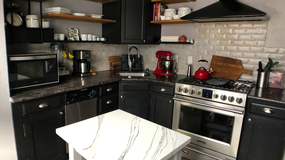 Kitchen with black granite countertops and a stainless steel gas oven