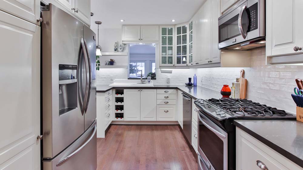 A modern kitchen with all-new appliance including a refrigerator, oven, and microwave